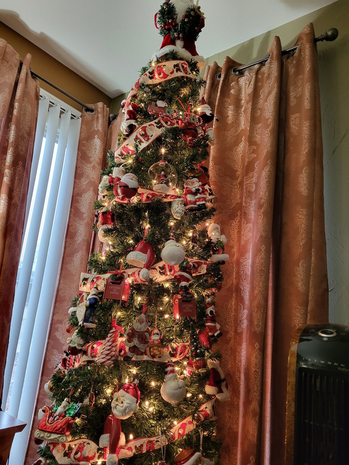 Detail of a slim Christmas tree layered with ribbon and ornaments