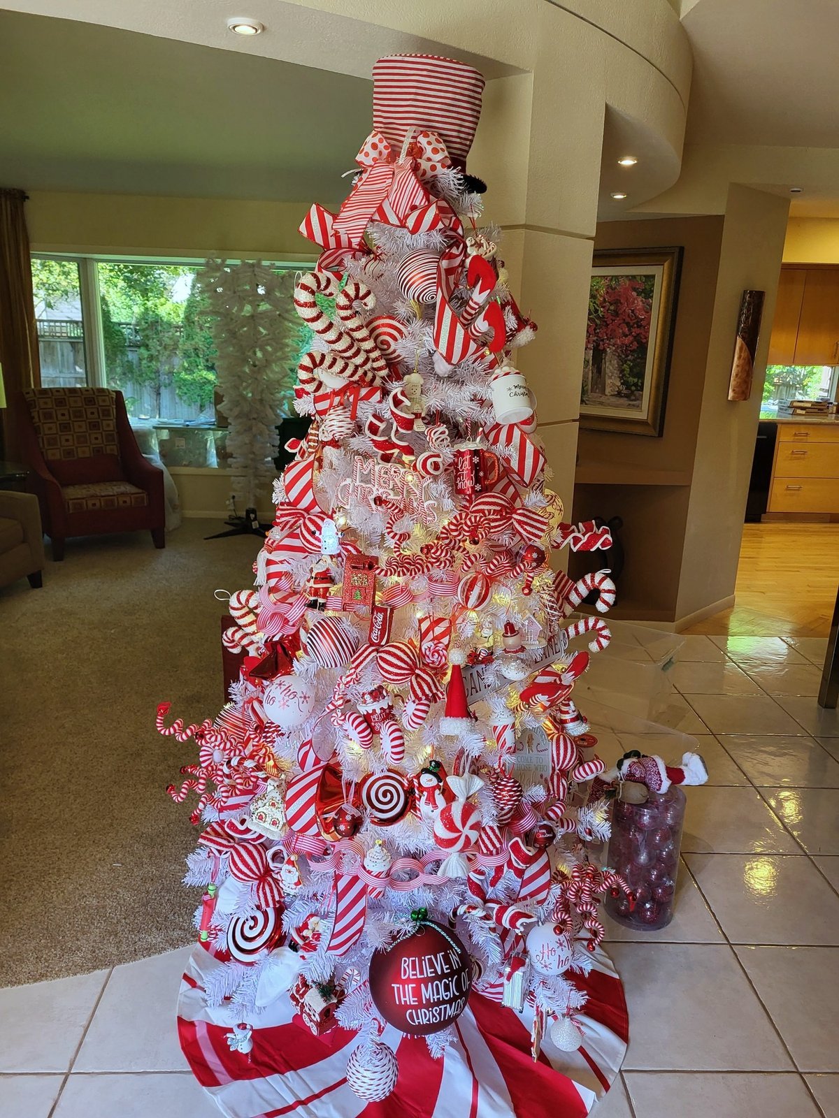 Candy cane themed Christmas tree in red and white with striped ribbon and peppermint ornaments