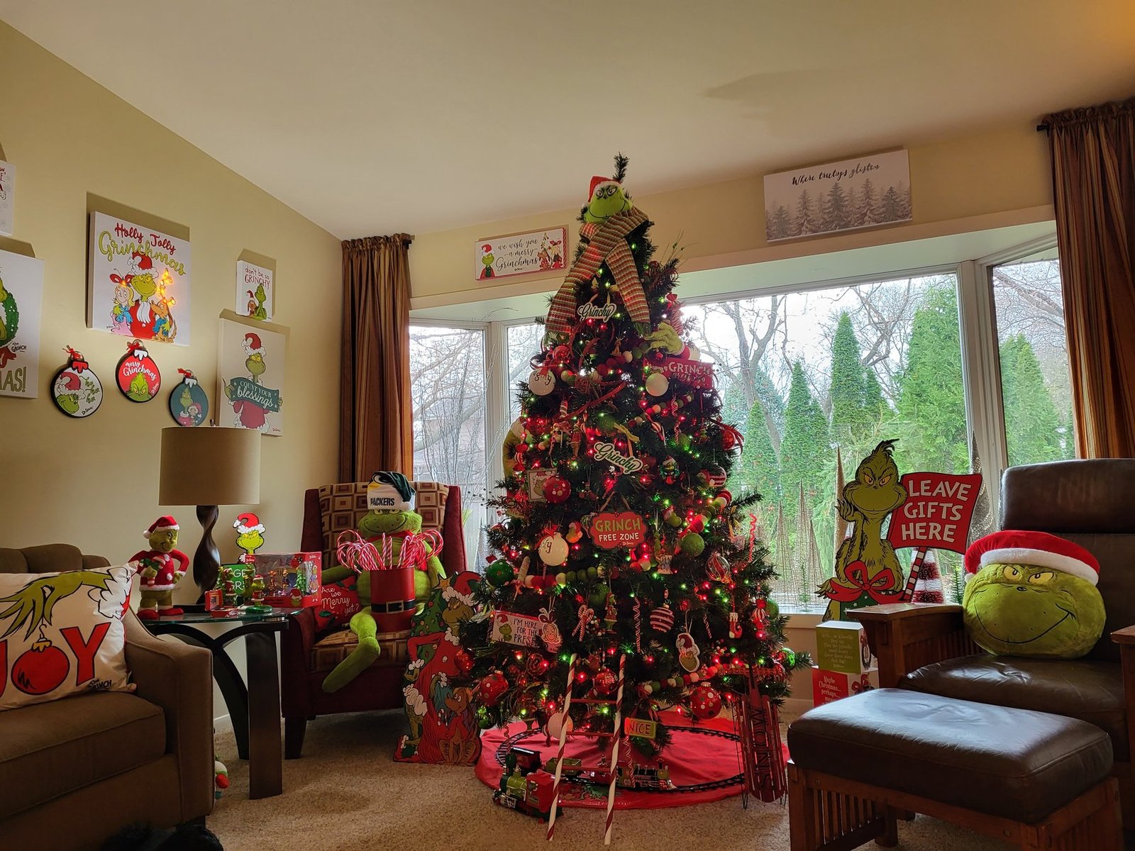 Grinch themed Christmas tree with red and green ornaments in a living room