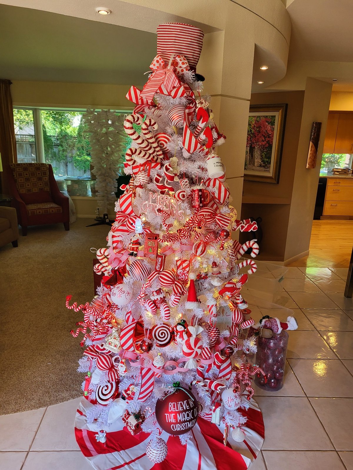 Candy cane themed Christmas tree in red and white with striped ribbon and peppermint ornaments
