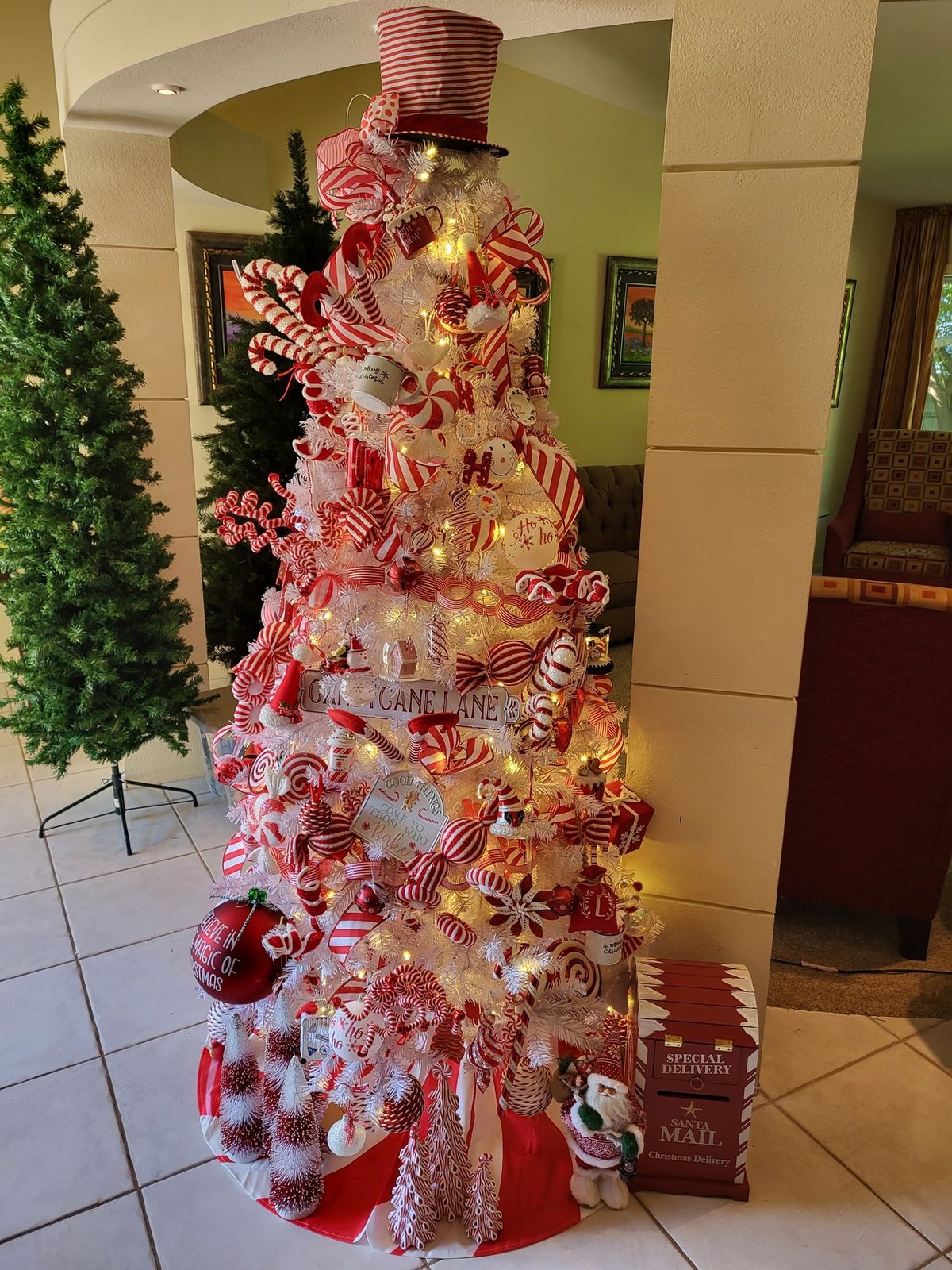 Candy cane Christmas tree topped with a red and white striped top hat