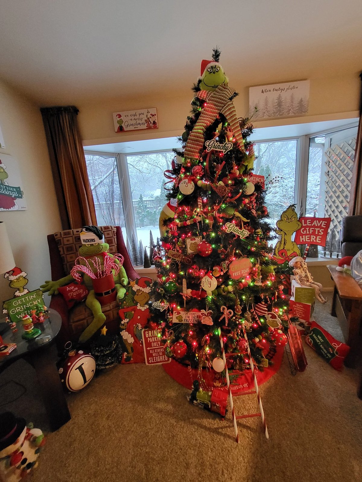Christmas tree with red and gold trim beside a window and wrapped gifts