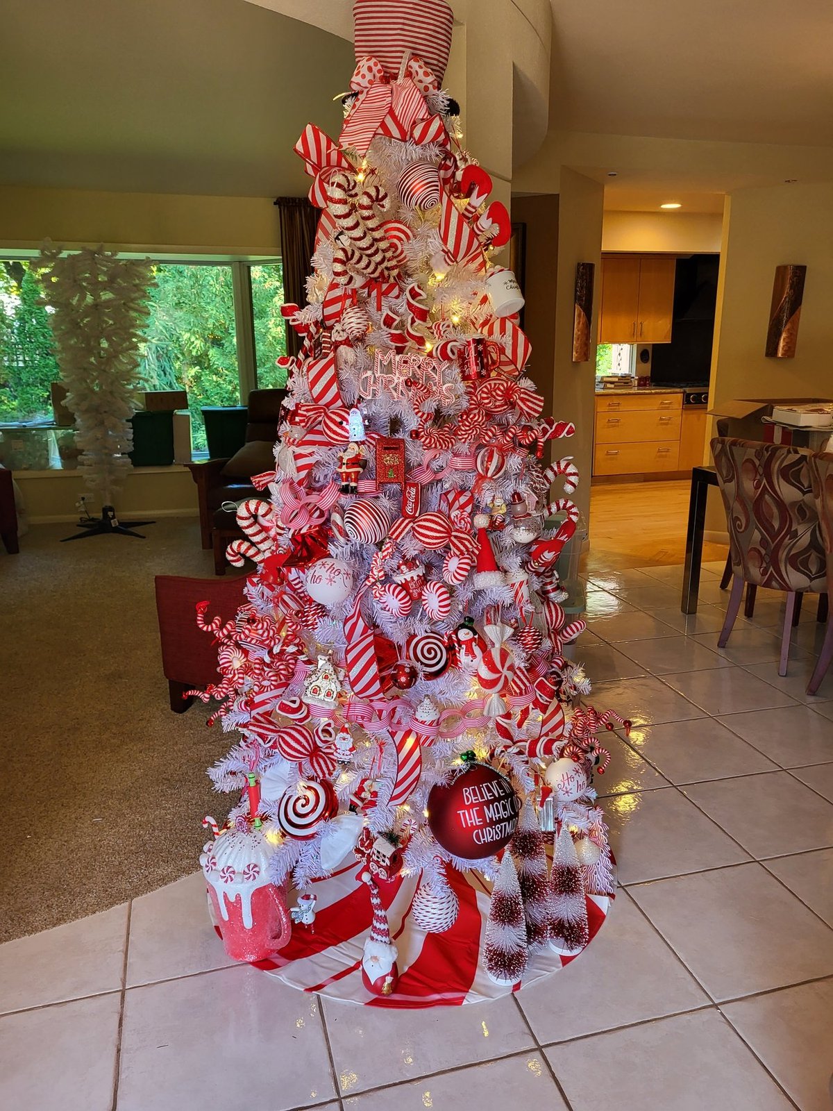 Candy cane themed Christmas tree beside a kitchen doorway