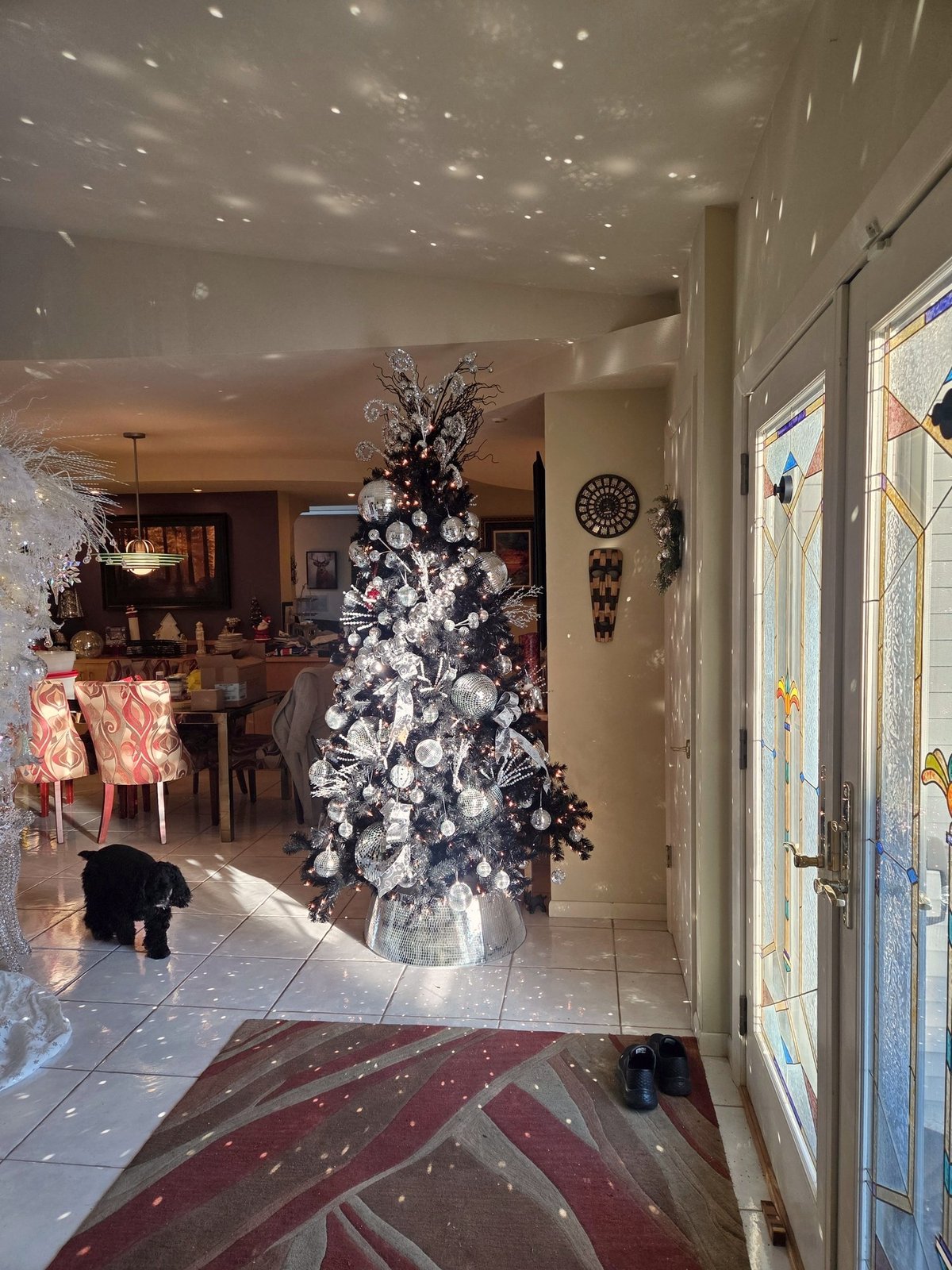 Living room with a decorated Christmas tree and holiday displays on the shelves