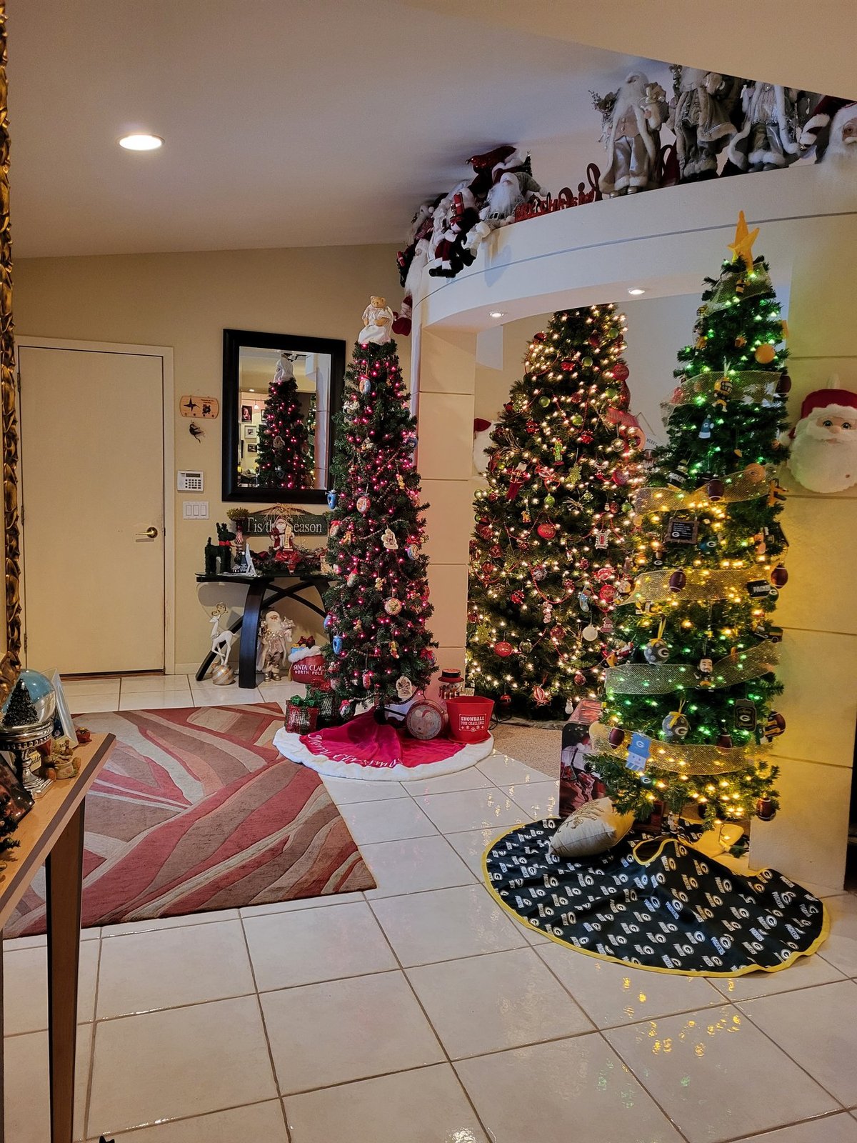 Two decorated Christmas trees in a tiled entryway