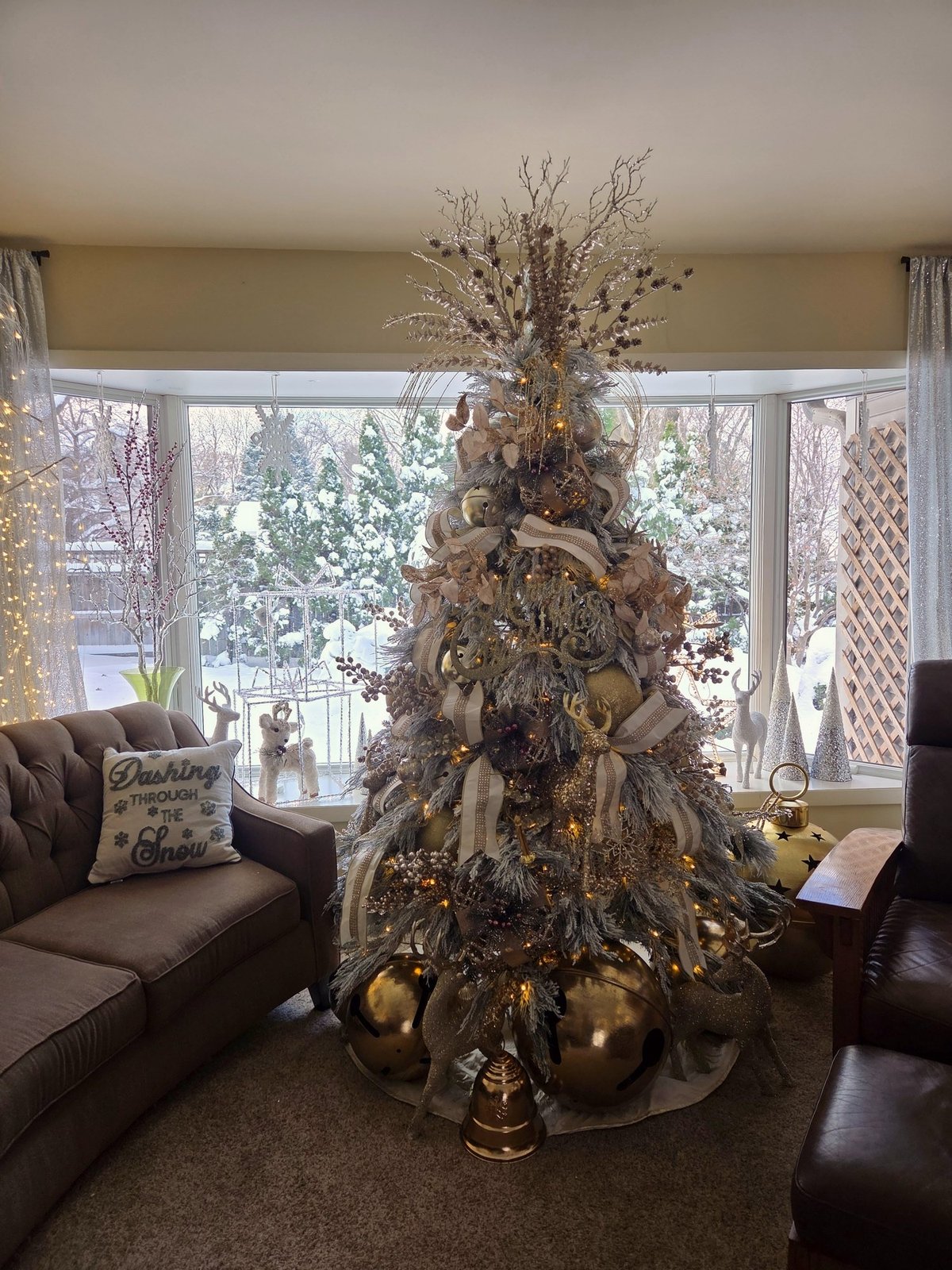 Flocked Christmas tree in a bay window with winter snow outside