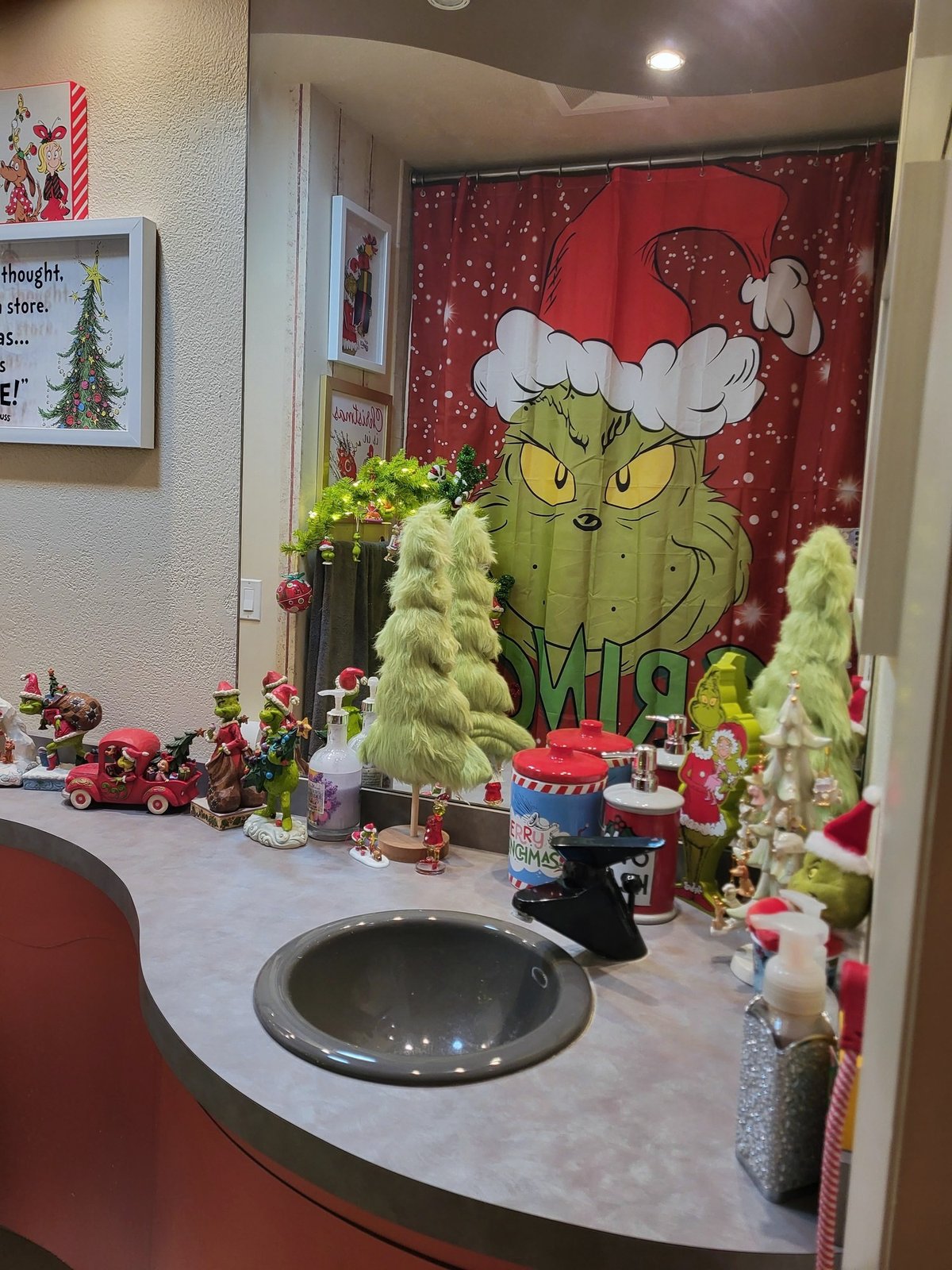 Grinch figurines and small green trees arranged as a holiday display