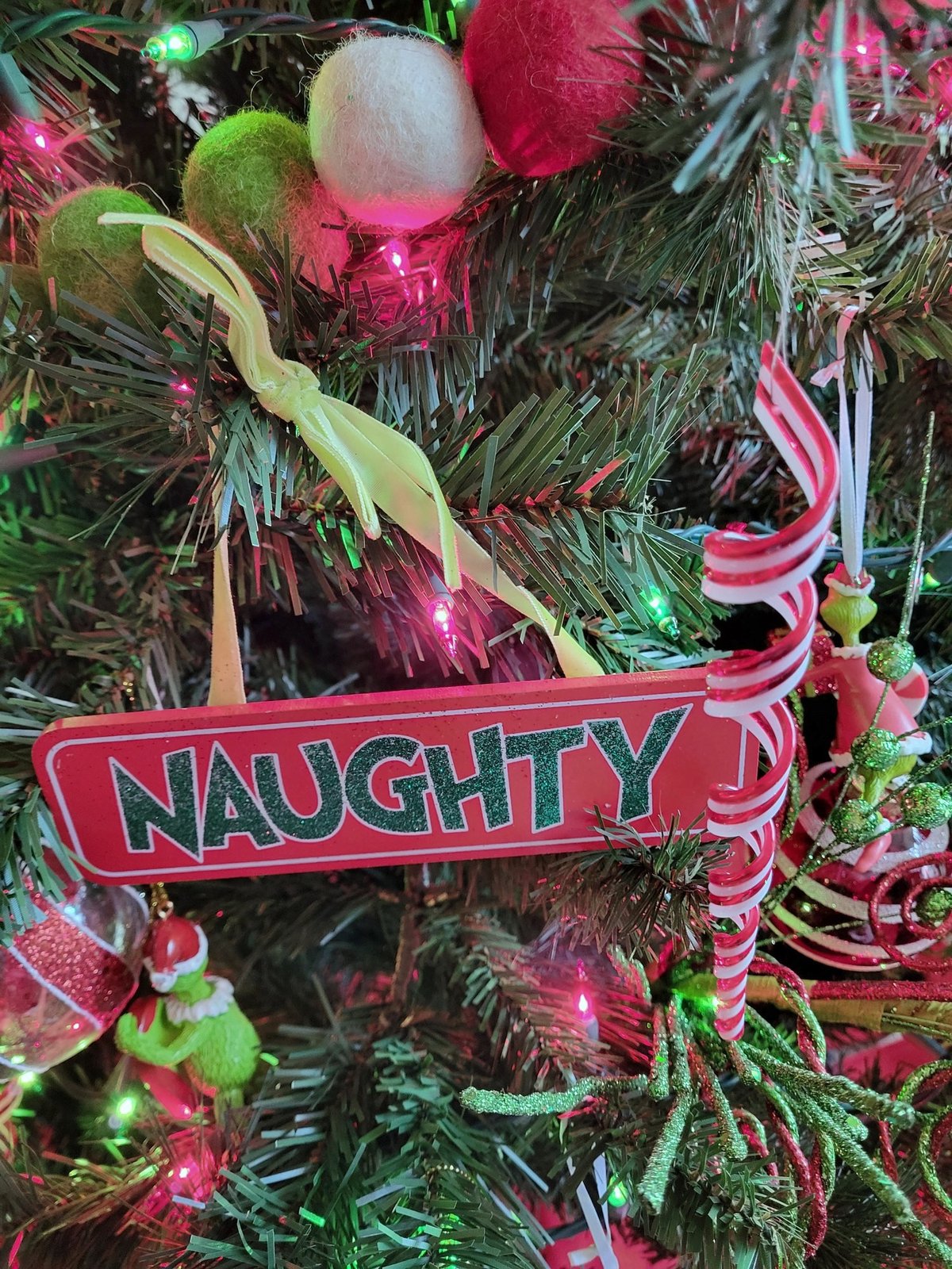 Grinch themed Christmas tree with a Naughty sign and red and green ornaments