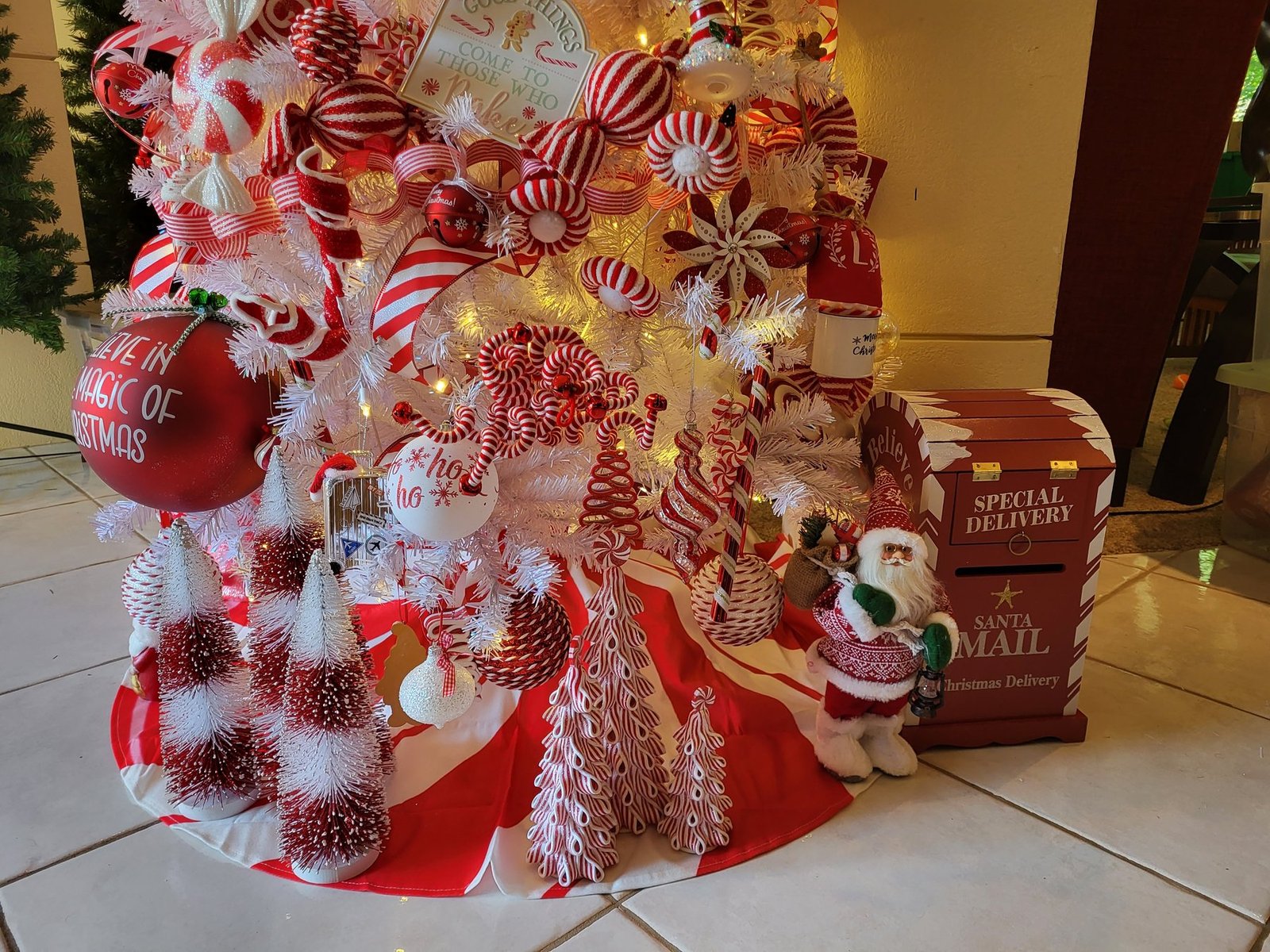Base of a candy cane tree with a Santa mail crate and small trees