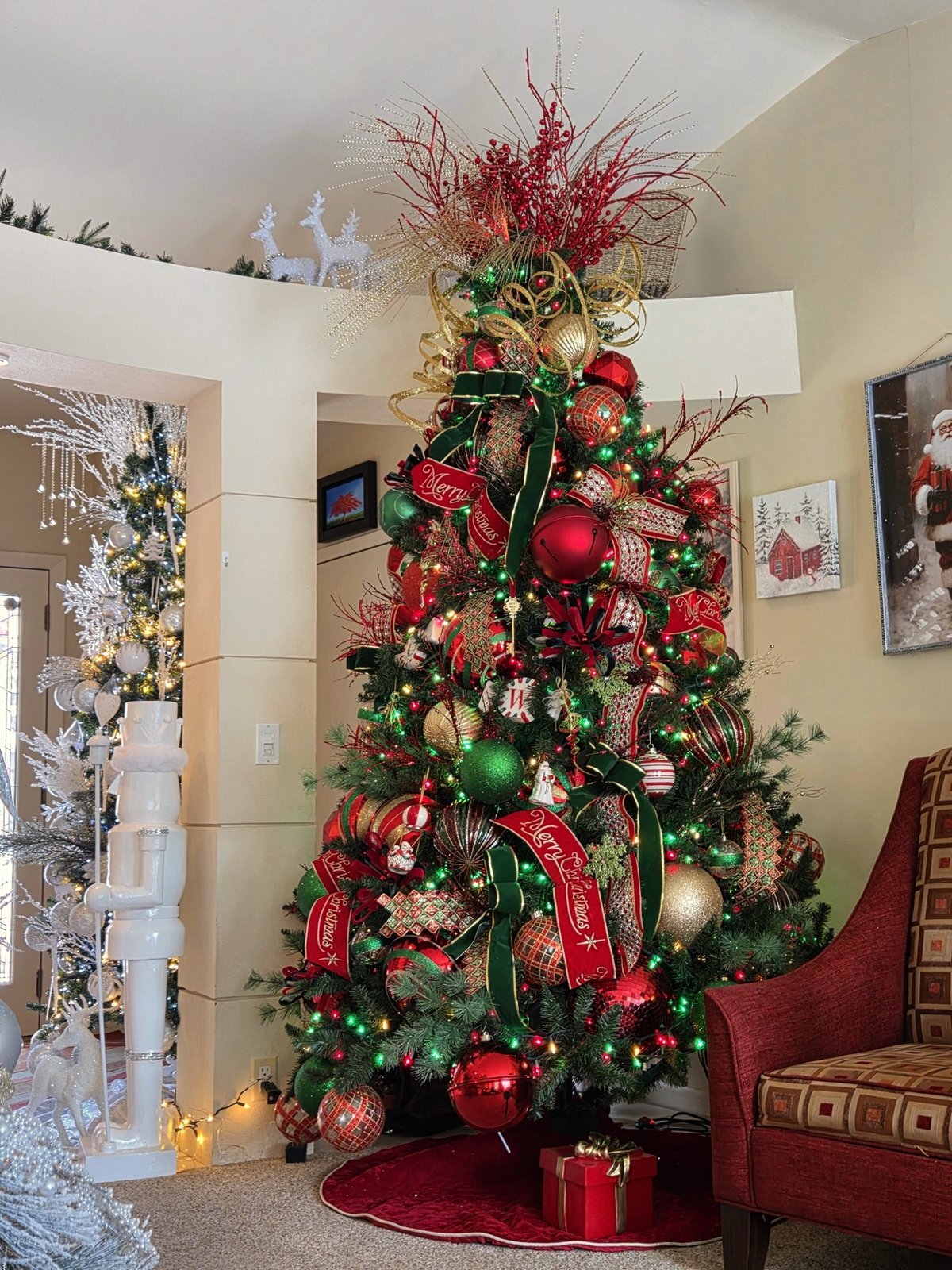Christmas tree decorated in red, green and gold with wide ribbon woven through the branches