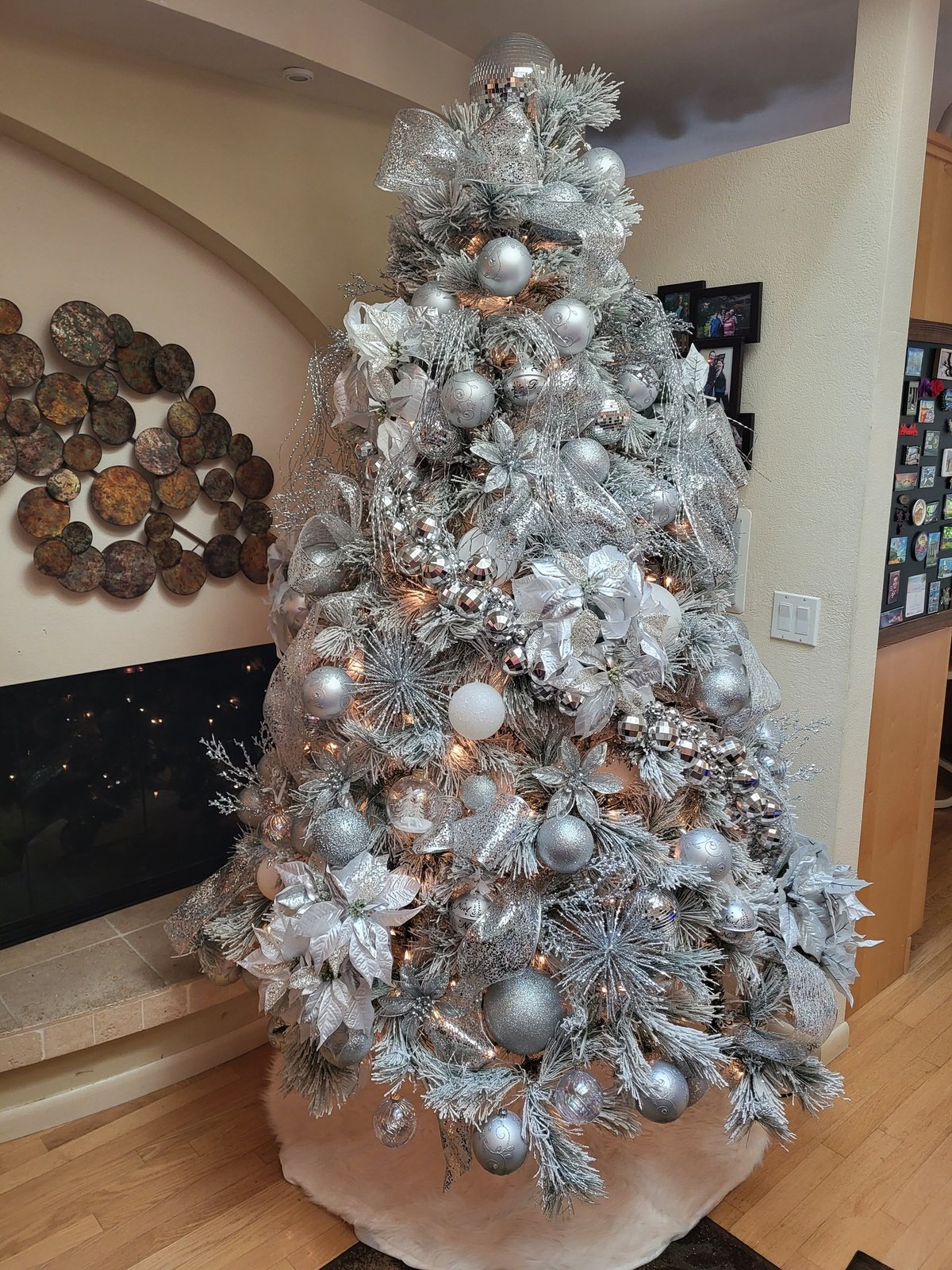 Silver and white Christmas tree with layered ornaments and silver picks