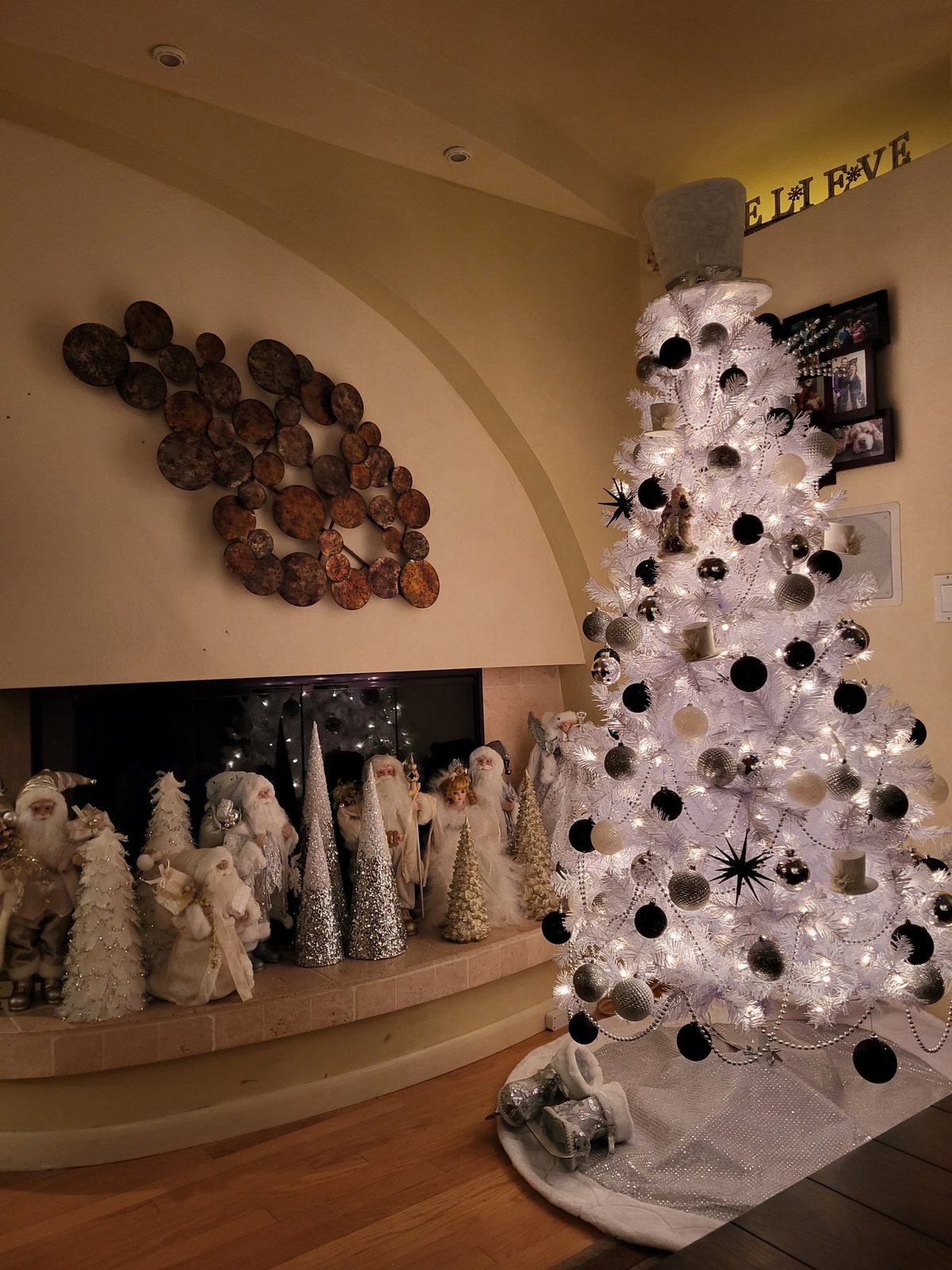 White Christmas tree with black ornaments above a display of white village figures